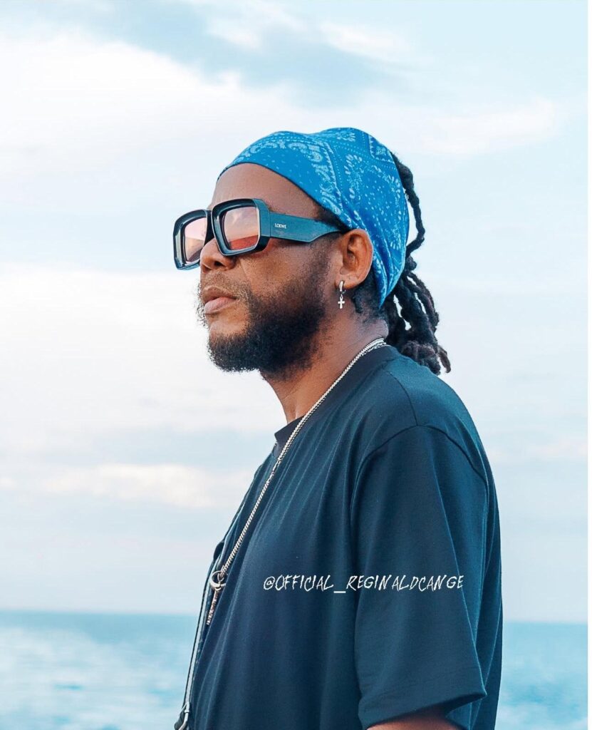 Réginald Cangé, chanteur haïtien de renom en profil, portant un bandana bleu et des lunettes de soleil.